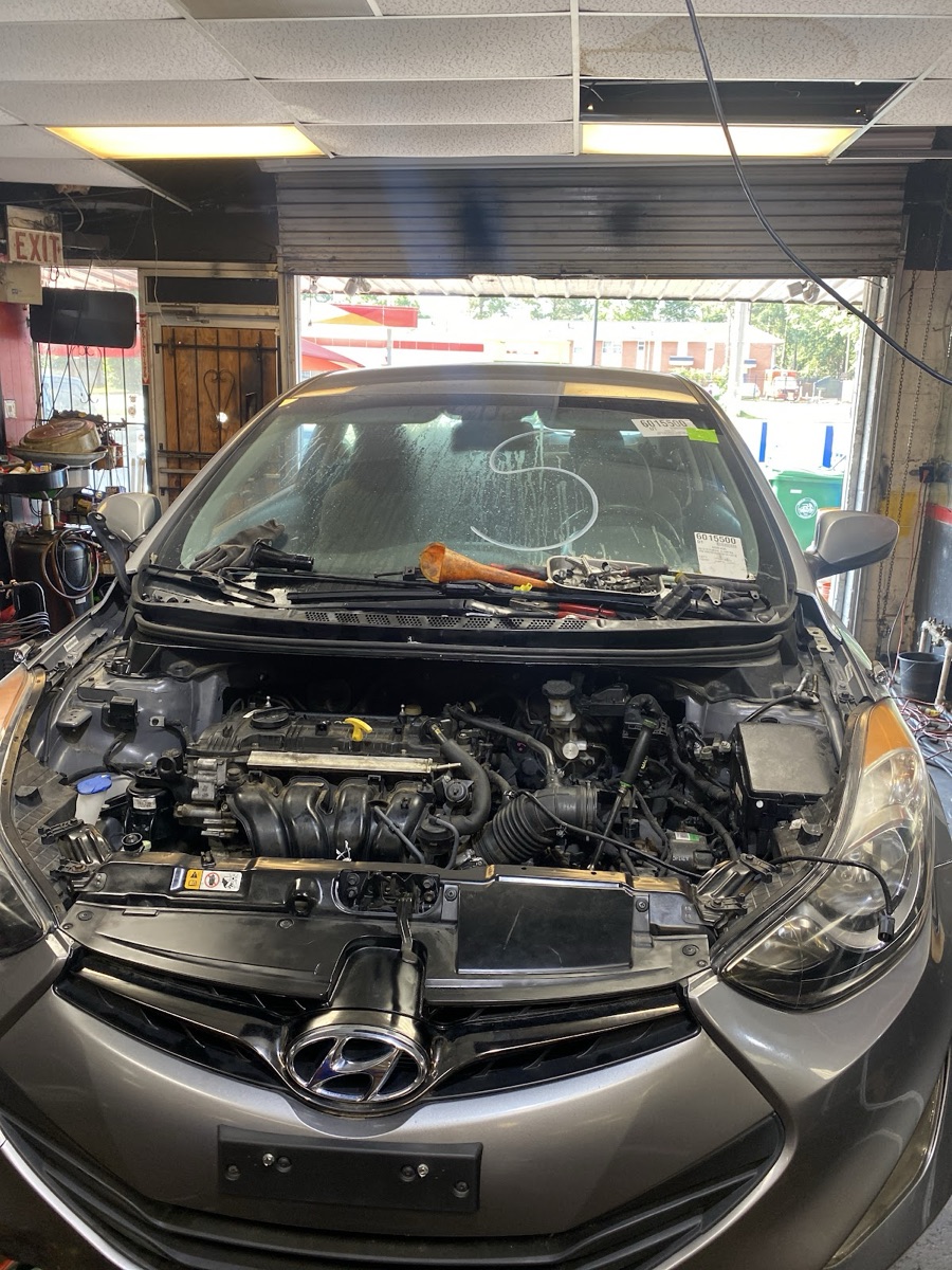 A car with the hood up in the service bay at Nai's Auto Repair, mid-diagnosis