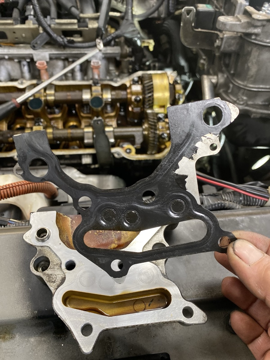 Bac inspecting a gasket against a disassembled cylinder head at Nai's Auto Repair